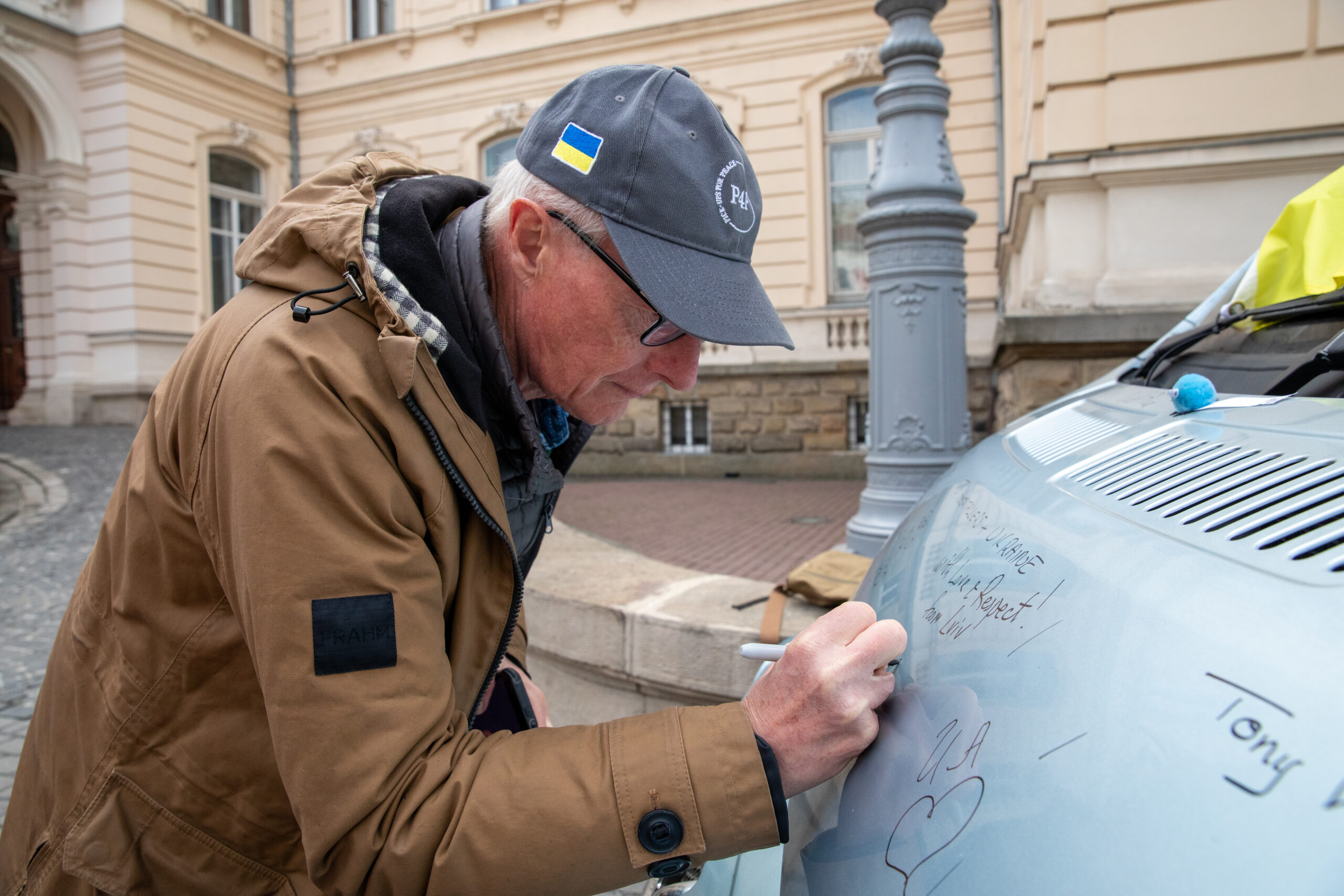 A supporter signing a Pickups for Peace vehicle
