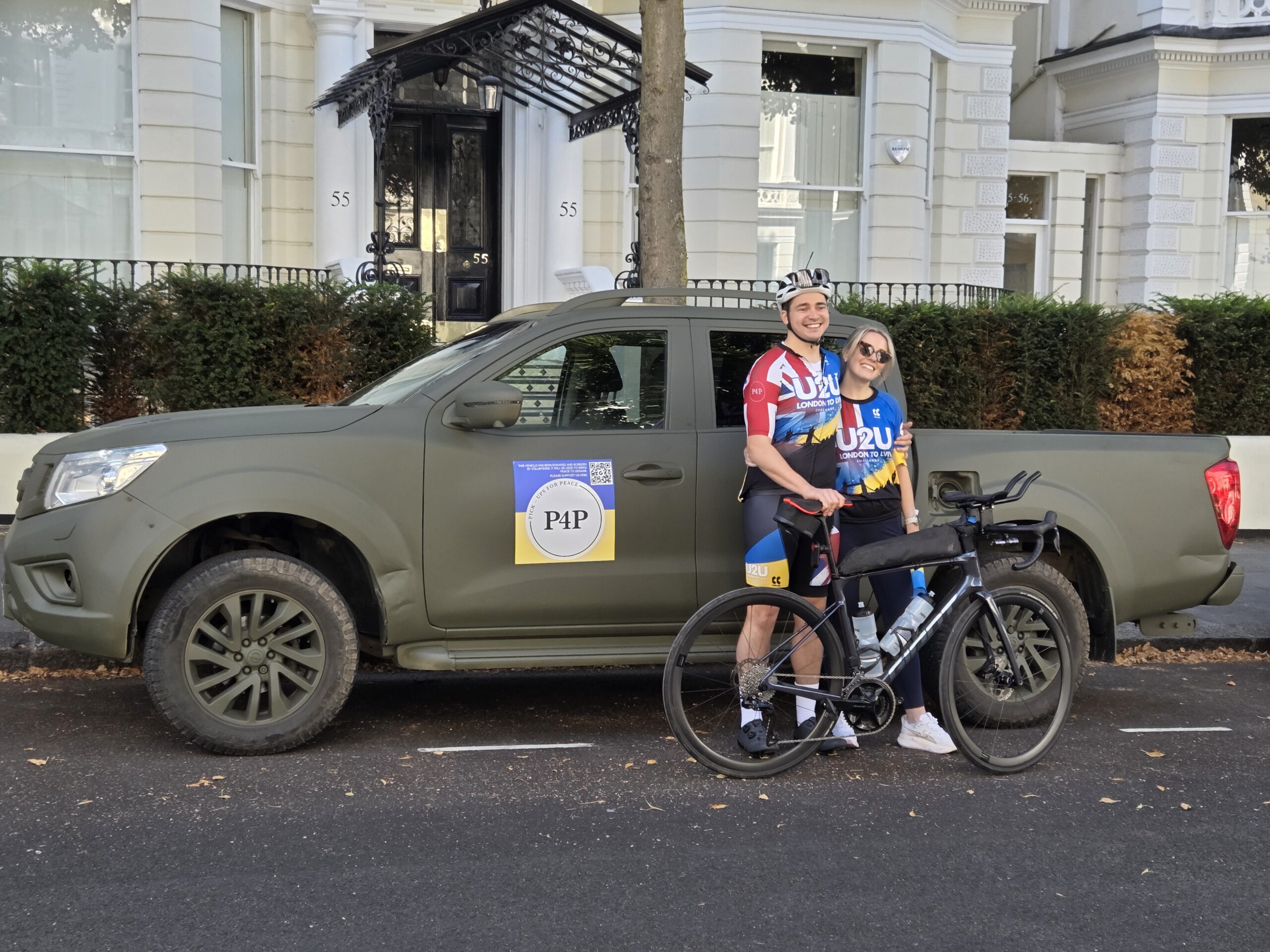 Matt Scarsi and Sarah beside the Pickups for Peace support vehicle and Matt's bicycle
